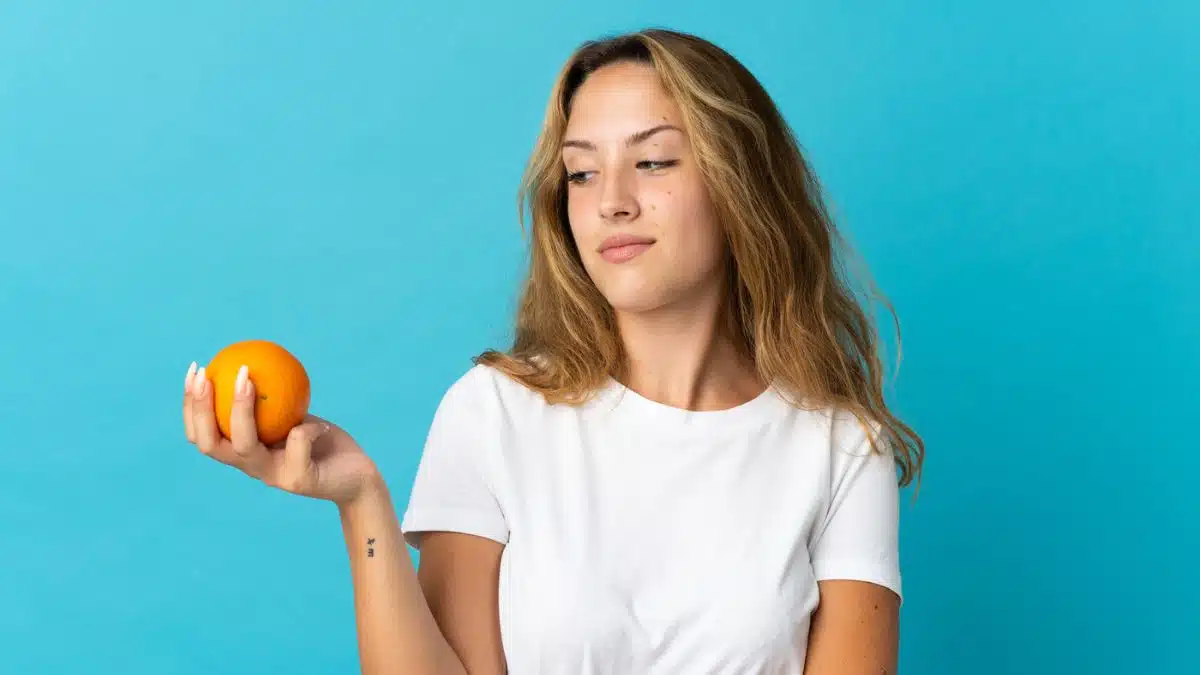 woman holding an orange