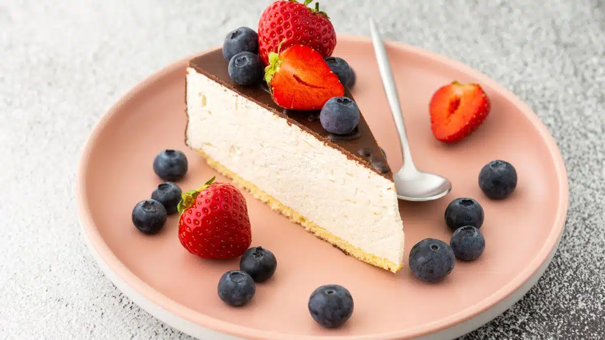 A piece of cheesecake covered with chocolate wit