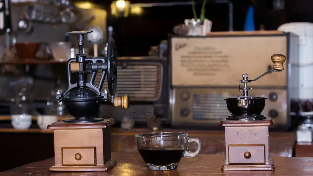 Coffee grinders and black coffee cups are on the table.