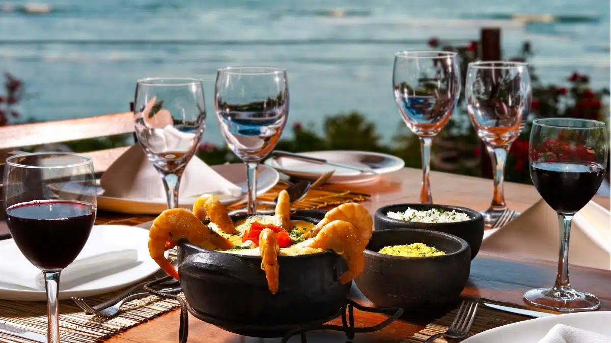 Shrimp and fish moqueca with the sea in the background
