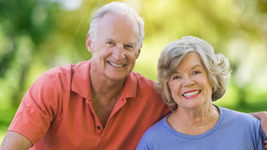 elder couple on bikes smiling