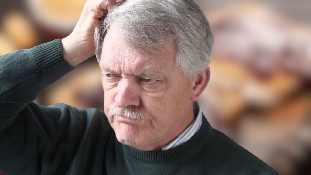 old man scratching head